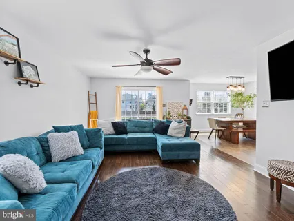 a living room with furniture a flat screen tv and a window