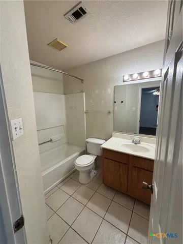 a bathroom with a granite countertop sink mirror vanity and toilet