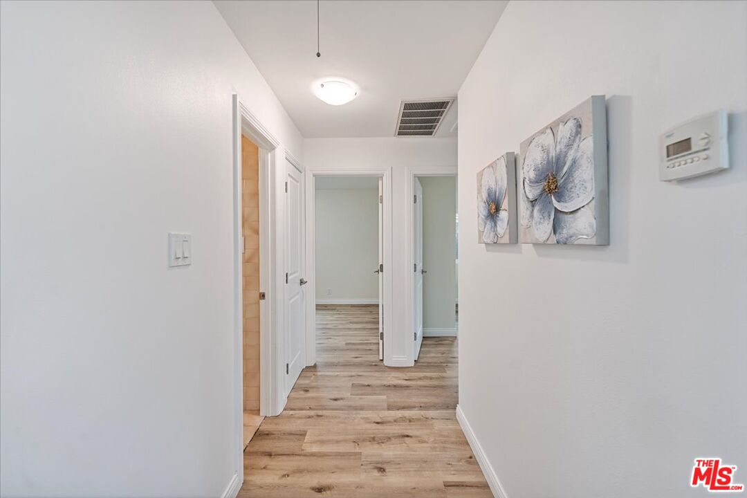 8605 Penny Drive Riverside, CA 92503 - Photo 11 of 22 a view of a hallway with wooden floor and closet