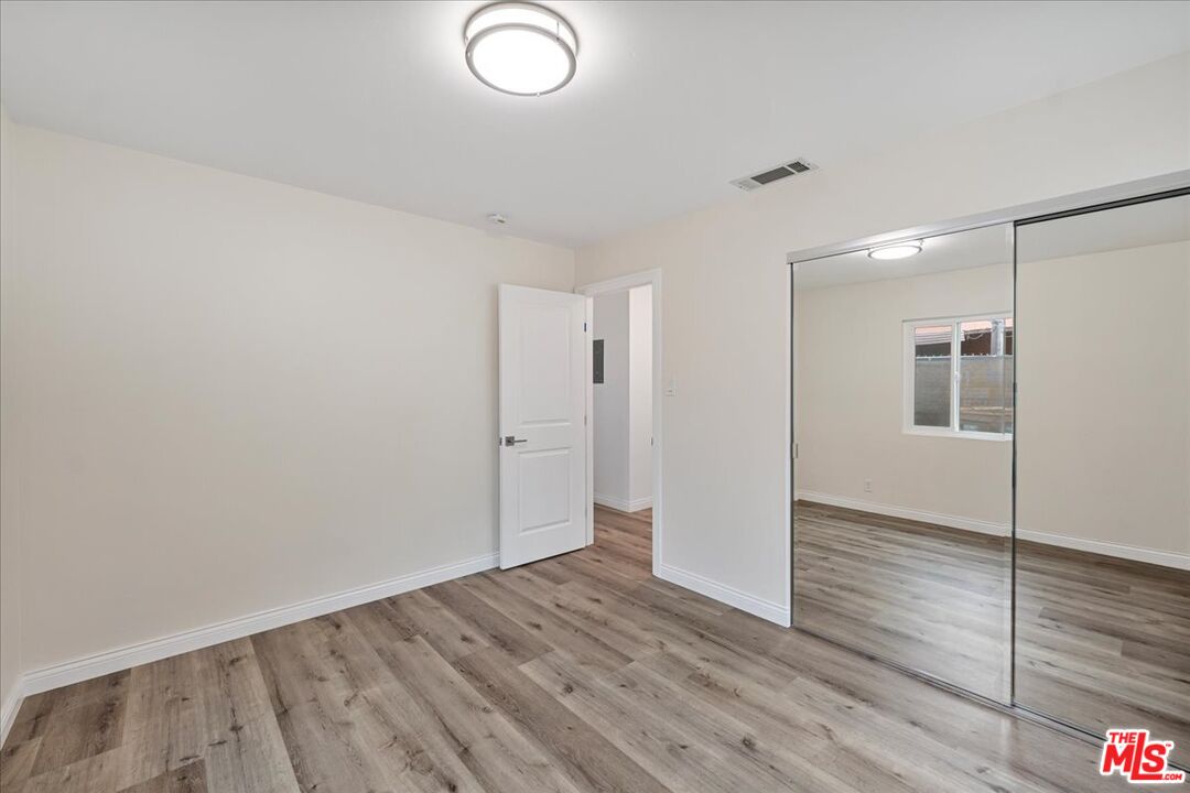 8605 Penny Drive Riverside, CA 92503 - Photo 18 of 22 an empty room with wooden floor and windows