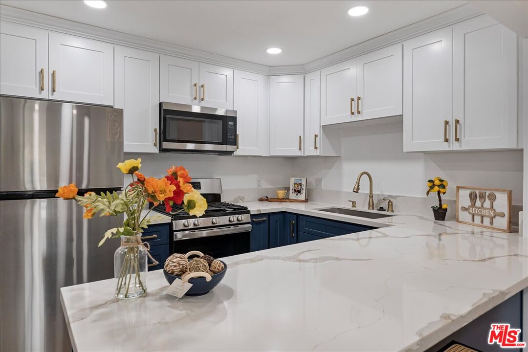 8605 Penny Drive Riverside, CA 92503 - Photo 6 of 22 a kitchen with stainless steel appliances granite countertop a sink dishwasher a refrigerator and cabinets with wooden floor