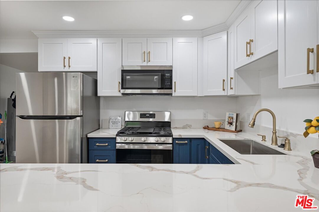 8605 Penny Drive Riverside, CA 92503 - Photo 8 of 22 a kitchen with stainless steel appliances granite countertop a refrigerator sink and stove