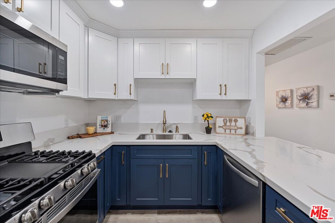 8605 Penny Drive Riverside, CA 92503 - Photo 9 of 22 a kitchen with stainless steel appliances granite countertop a sink stove and cabinets
