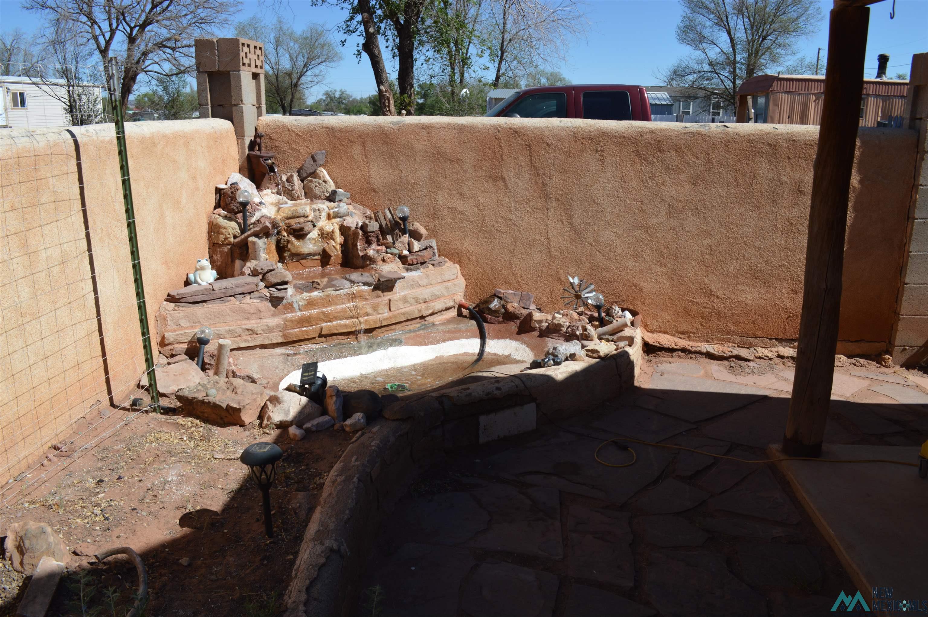 6 Sunny Dale Road Bluewater, NM 87005 - Photo 3 of 42 Terraced stone fountain feature with a surrounding rock garden, set against a stucco wall