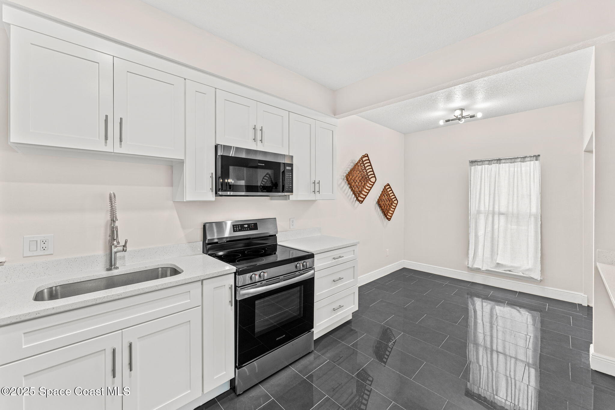 3037 S Highway, Unit 3C Melbourne Beach, FL 32951 - Photo 13 of 52 a kitchen with white cabinets stainless steel appliances and sink