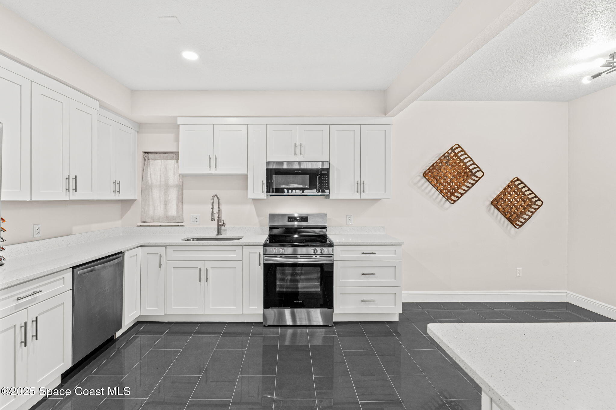 3037 S Highway, Unit 3C Melbourne Beach, FL 32951 - Photo 15 of 52 a kitchen with cabinets stainless steel appliances and a counter space