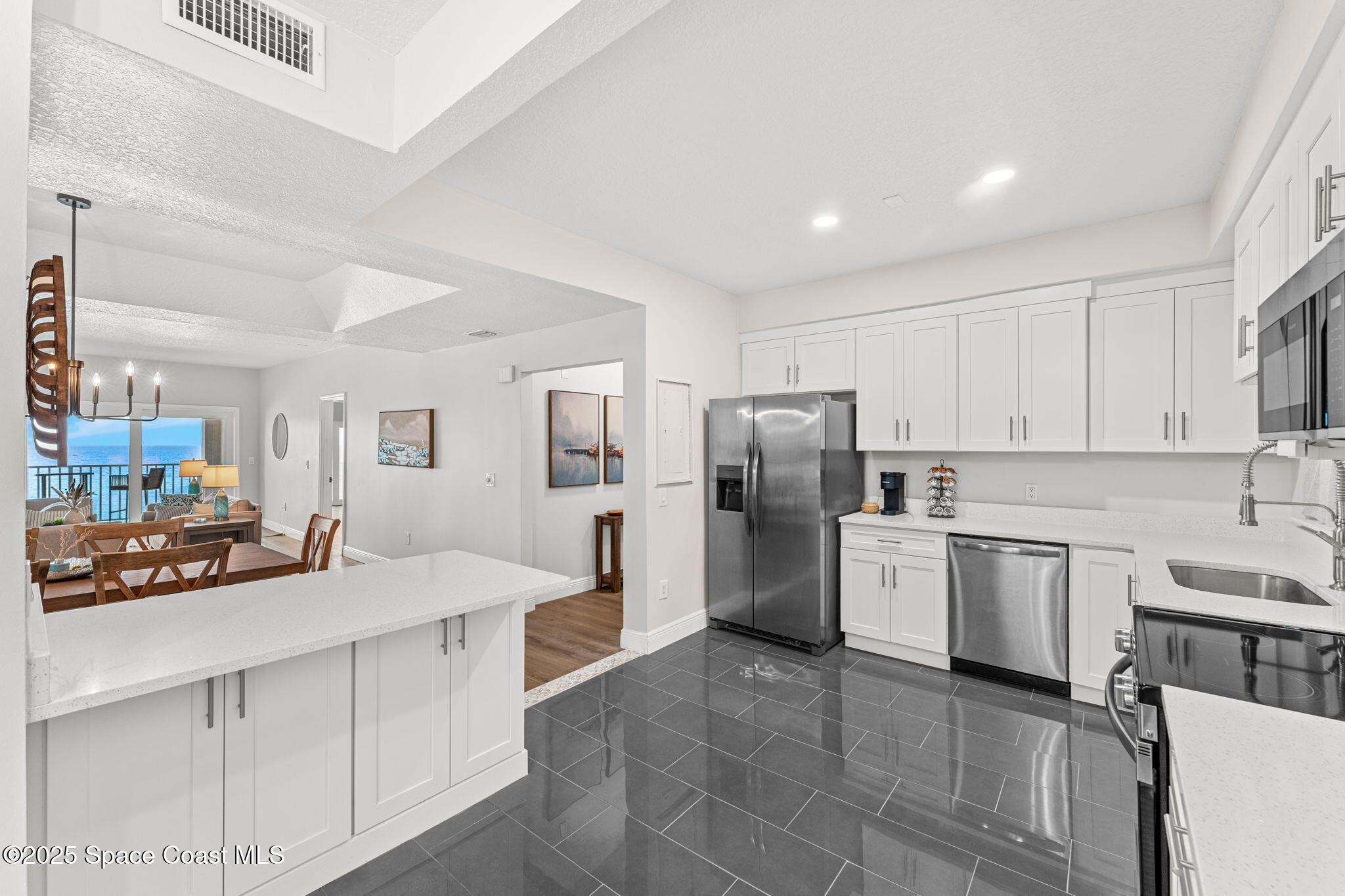 3037 S Highway, Unit 3C Melbourne Beach, FL 32951 - Photo 16 of 52 a kitchen with a sink cabinets and stainless steel appliances