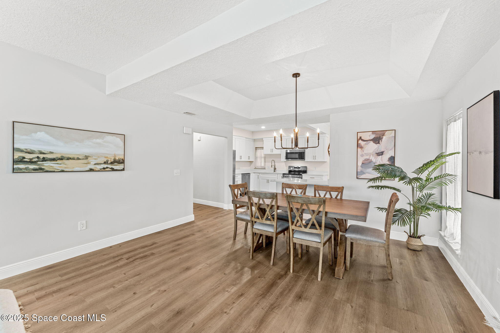 3037 S Highway, Unit 3C Melbourne Beach, FL 32951 - Photo 18 of 52 a view of a dining room with furniture wooden floor and chandelier