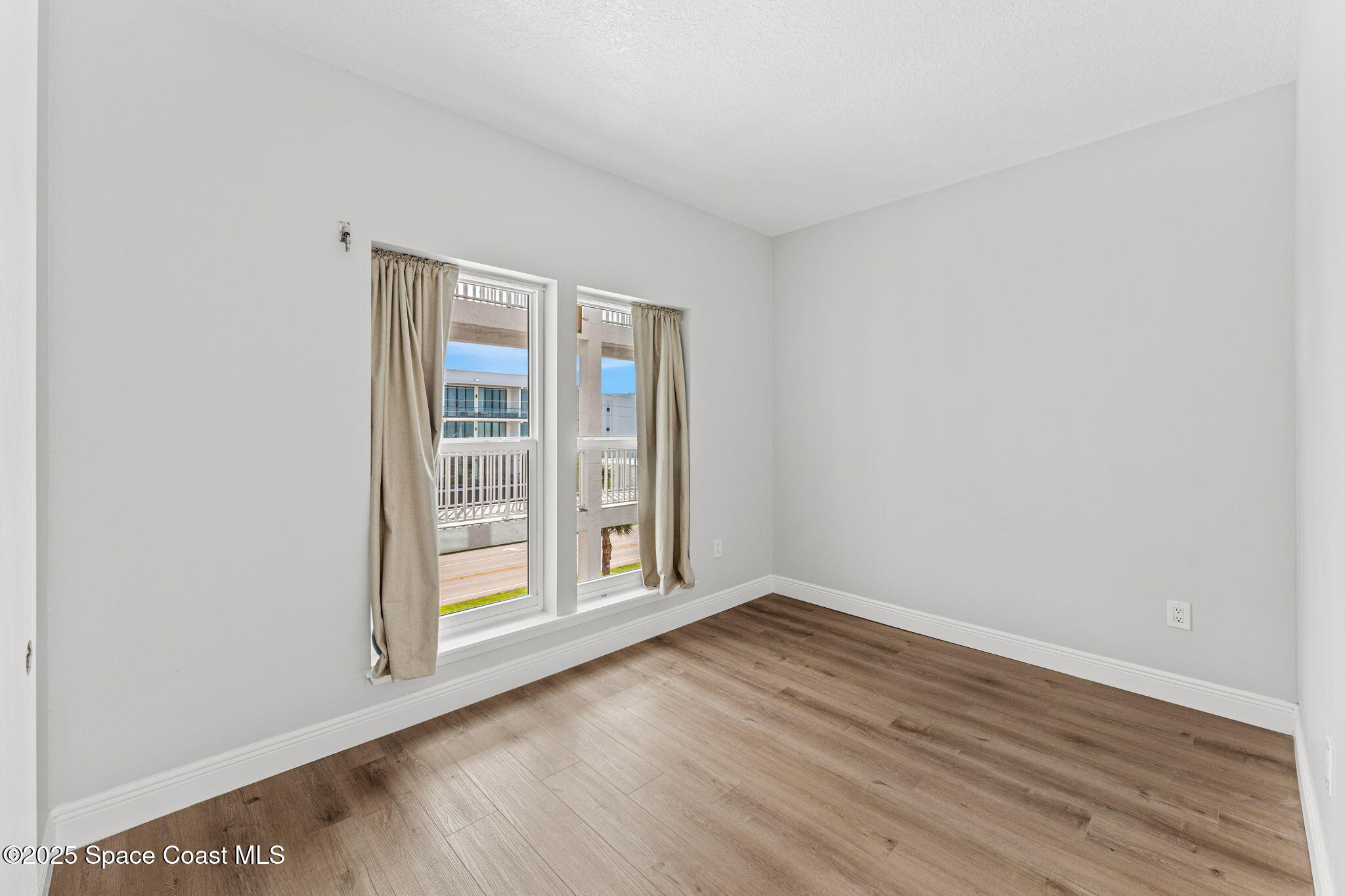3037 S Highway, Unit 3C Melbourne Beach, FL 32951 - Photo 24 of 52 wooden floor in an empty room with a window