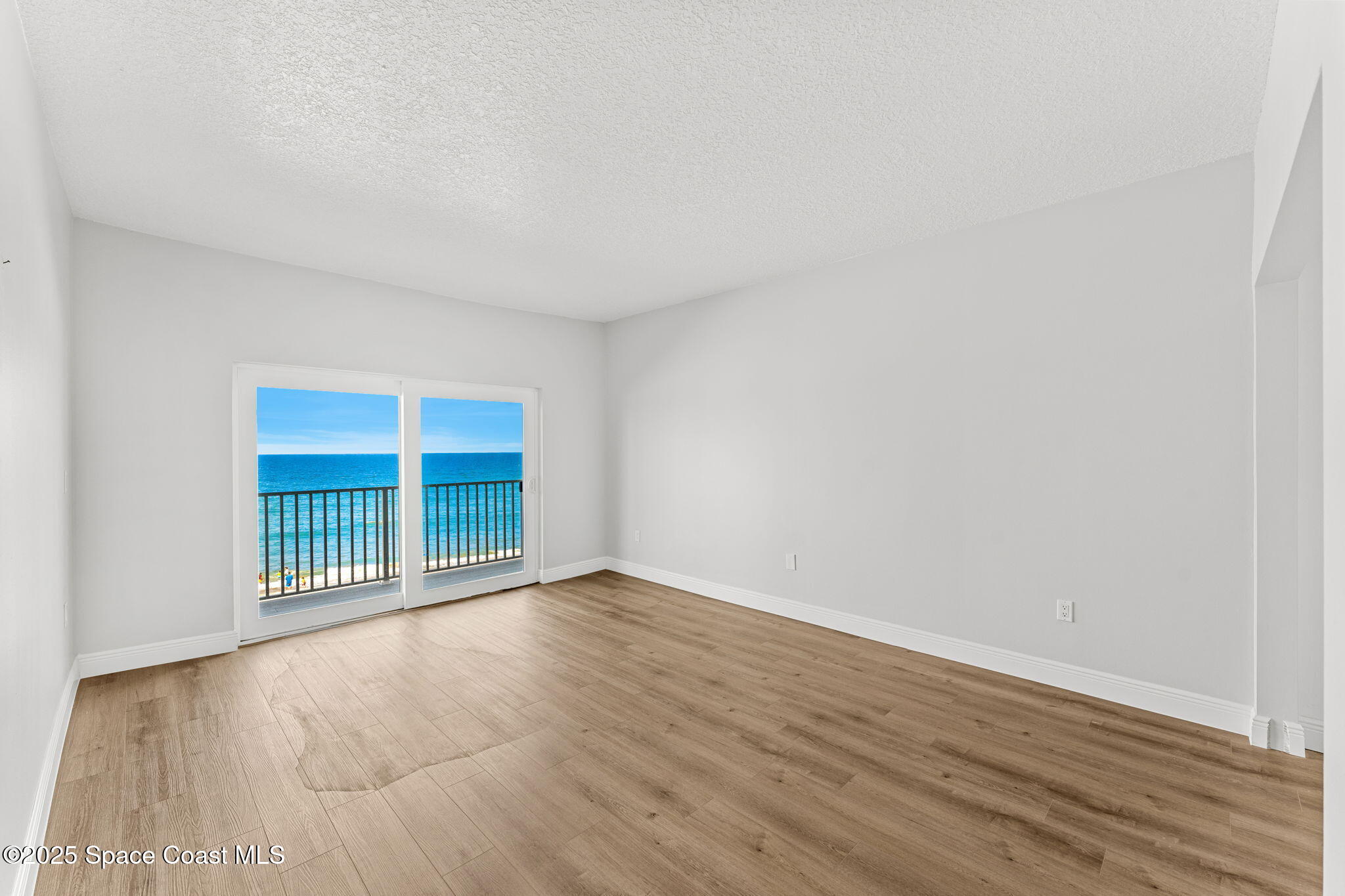 3037 S Highway, Unit 3C Melbourne Beach, FL 32951 - Photo 28 of 52 an empty room with wooden floor and windows