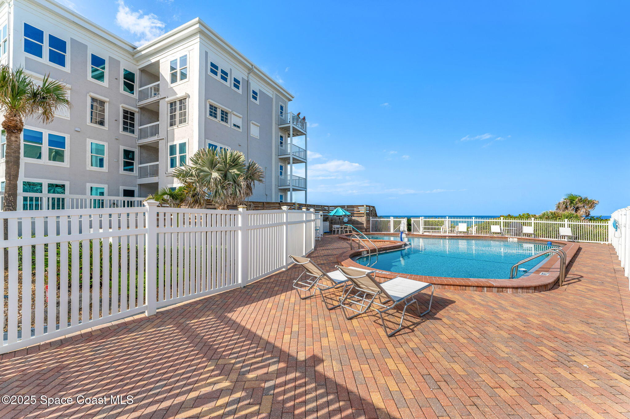 3037 S Highway, Unit 3C Melbourne Beach, FL 32951 - Photo 38 of 52 a view of a swimming pool with a lounge chairs