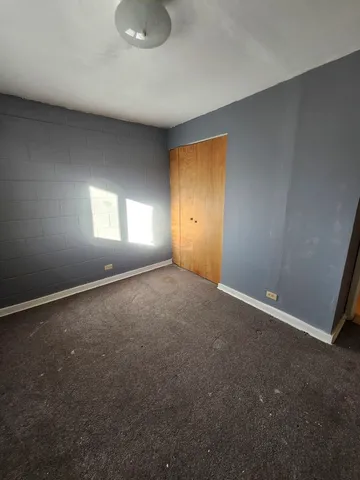 a view of an empty room with window and closet area