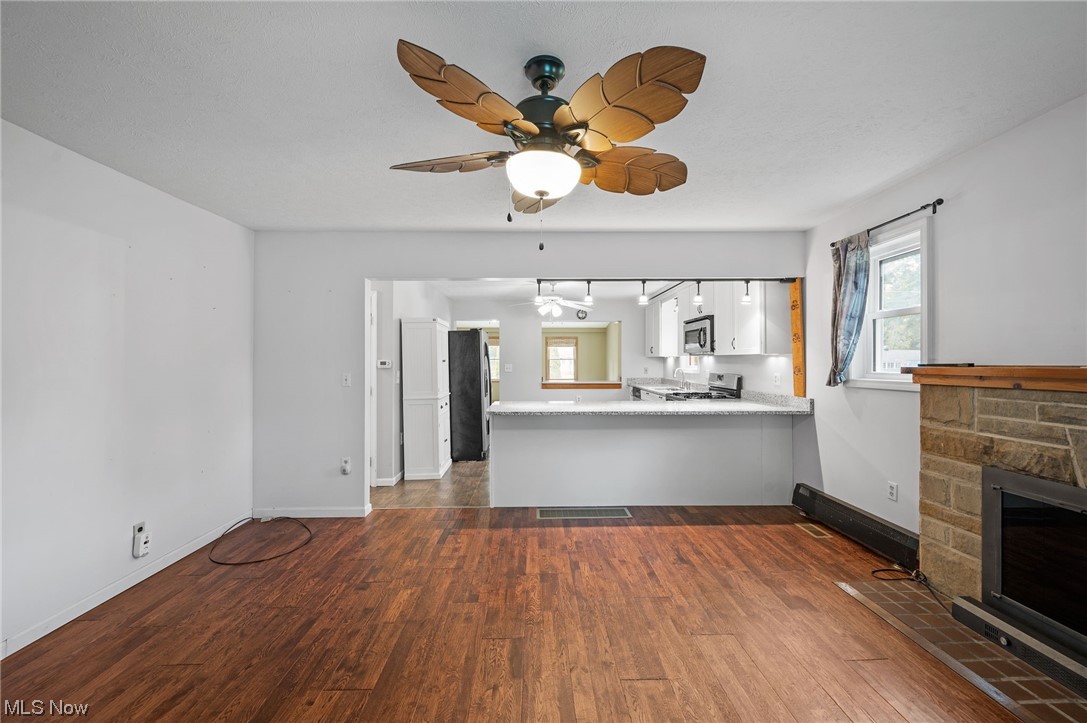 228 Cavalry Road Vermilion, OH 44089 - Photo 8 of 34 Hardwood floored living room featuring a fireplace and ceiling fan