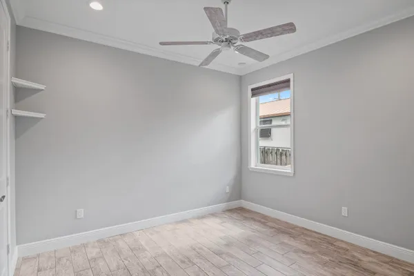 a view of an empty room with a window and a kitchen