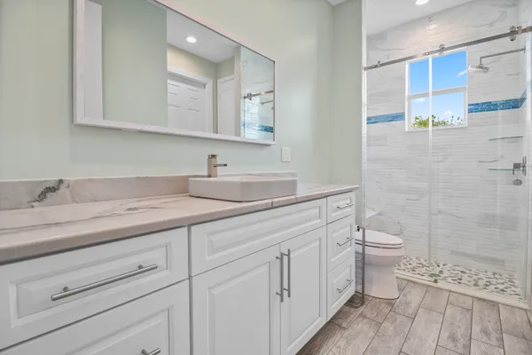 a bathroom with a sink a toilet and shower