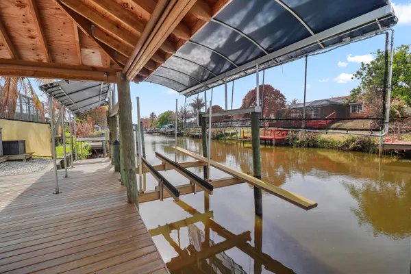 a view of a swimming pool with a table and chairs under an umbrella