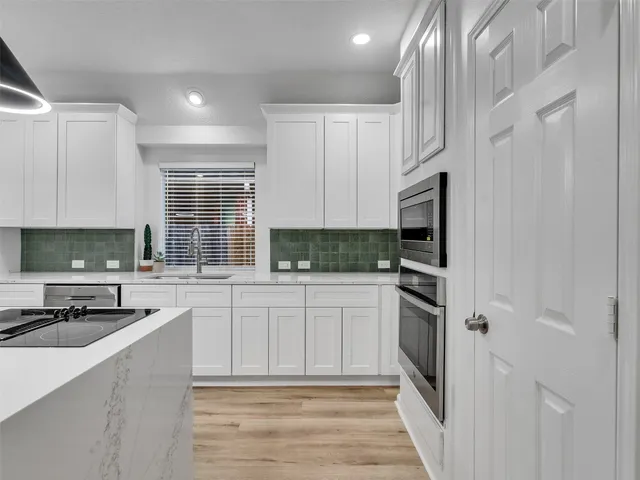 a kitchen with stainless steel appliances granite countertop a stove a sink and a refrigerator