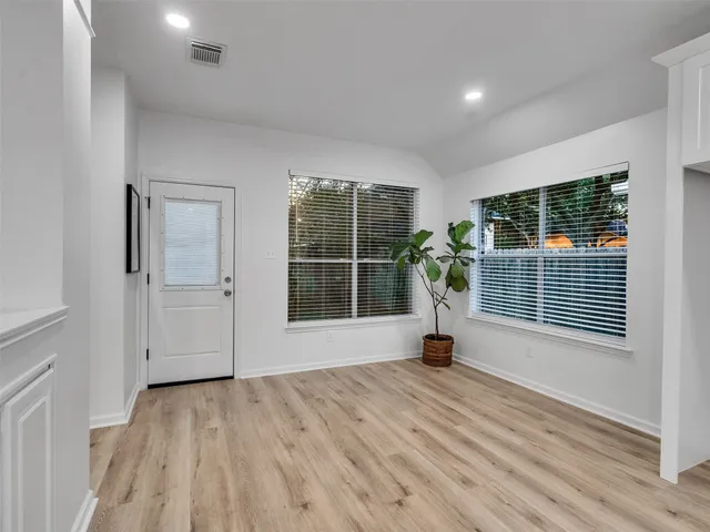 a view of a room with wooden floor and windows