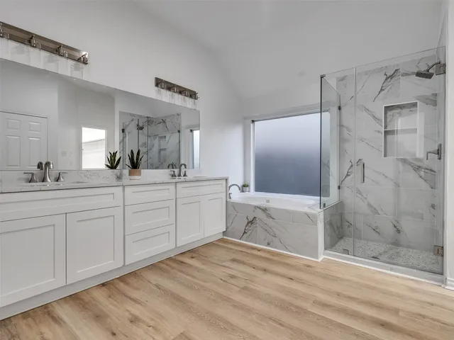 a bathroom with a double vanity sink mirror and shower