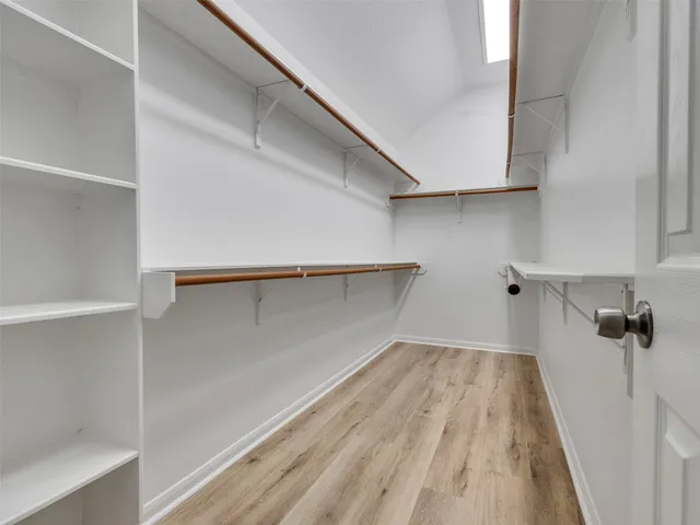a view of a room with wooden floor and cabinets