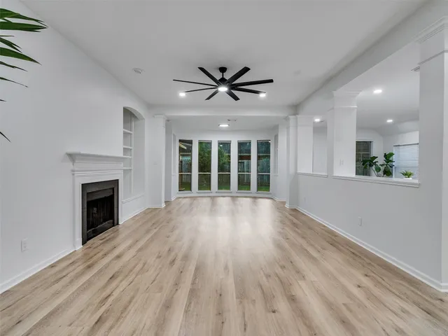 a view of an empty room with a fireplace and a window