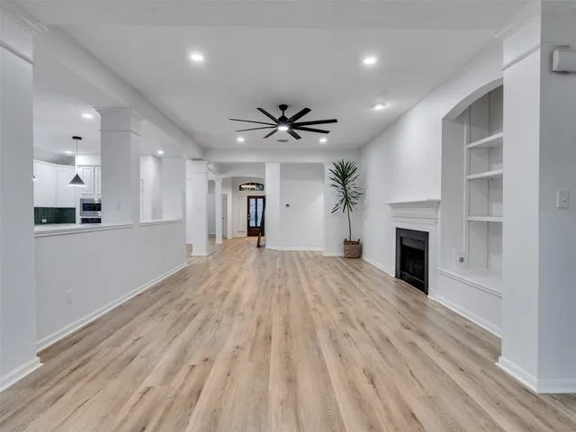 a view of an empty room with a fireplace and a window