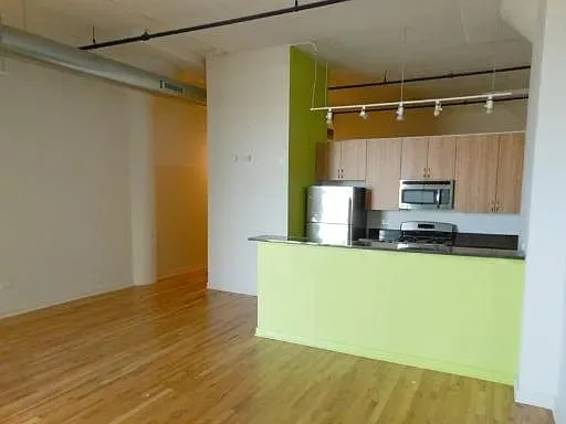a kitchen with a wooden floor and a refrigerator