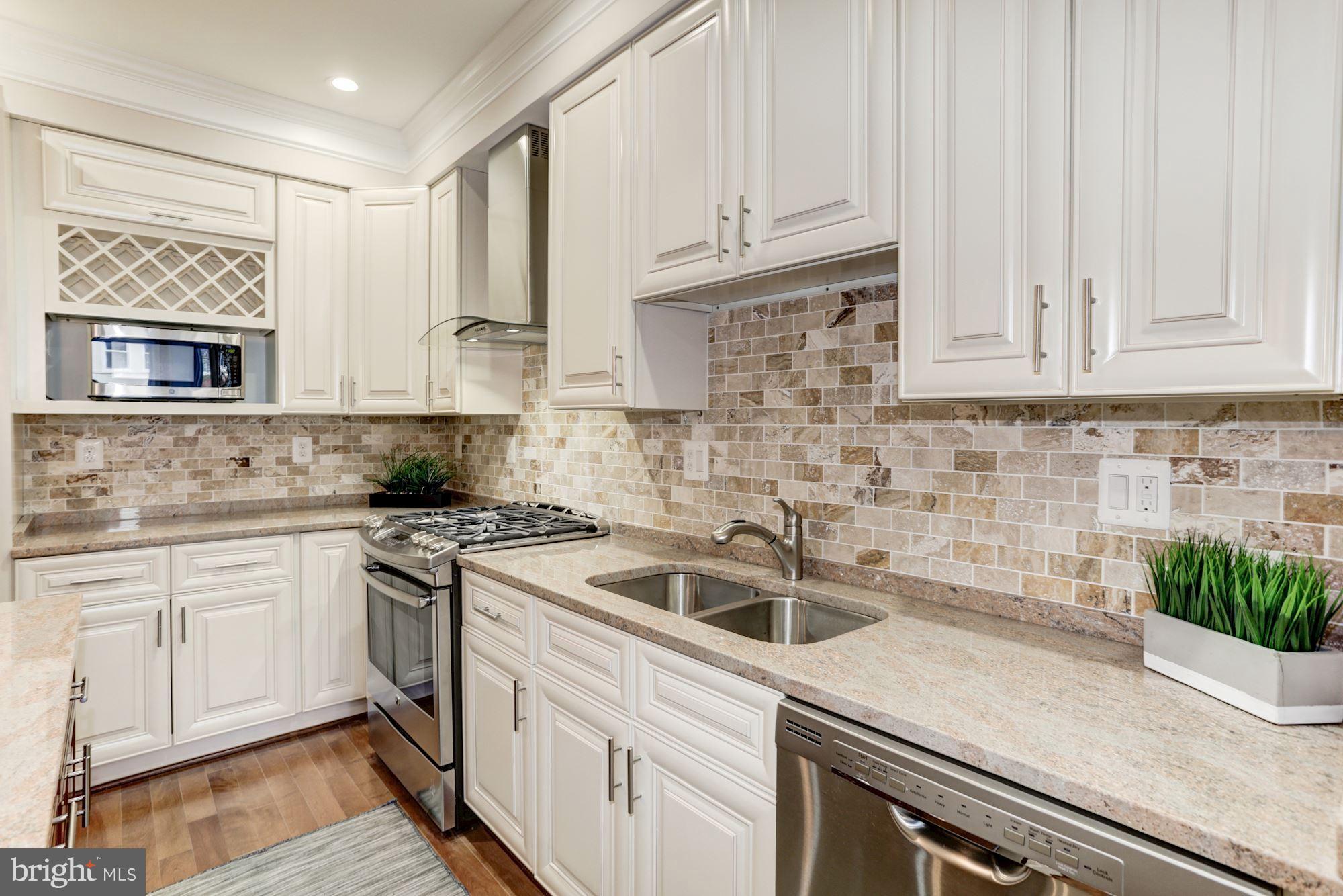 59 R Street Northeast, Unit 1 Washington, DC 20002 - Photo 13 of 40 a kitchen with granite countertop white cabinets and white appliances