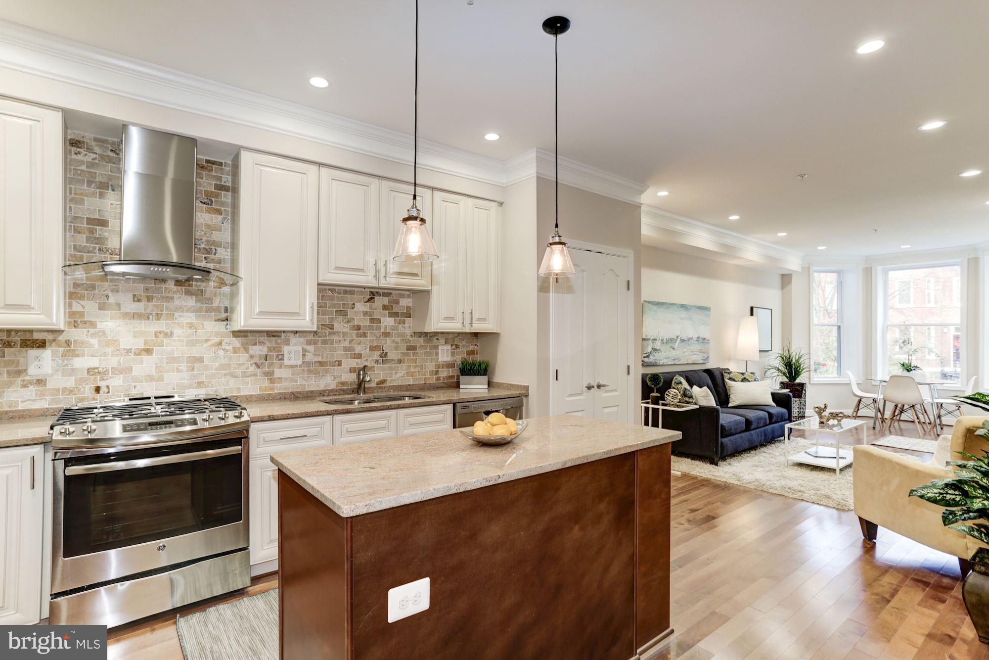 59 R Street Northeast, Unit 1 Washington, DC 20002 - Photo 14 of 40 a kitchen with a stove a sink and living room view