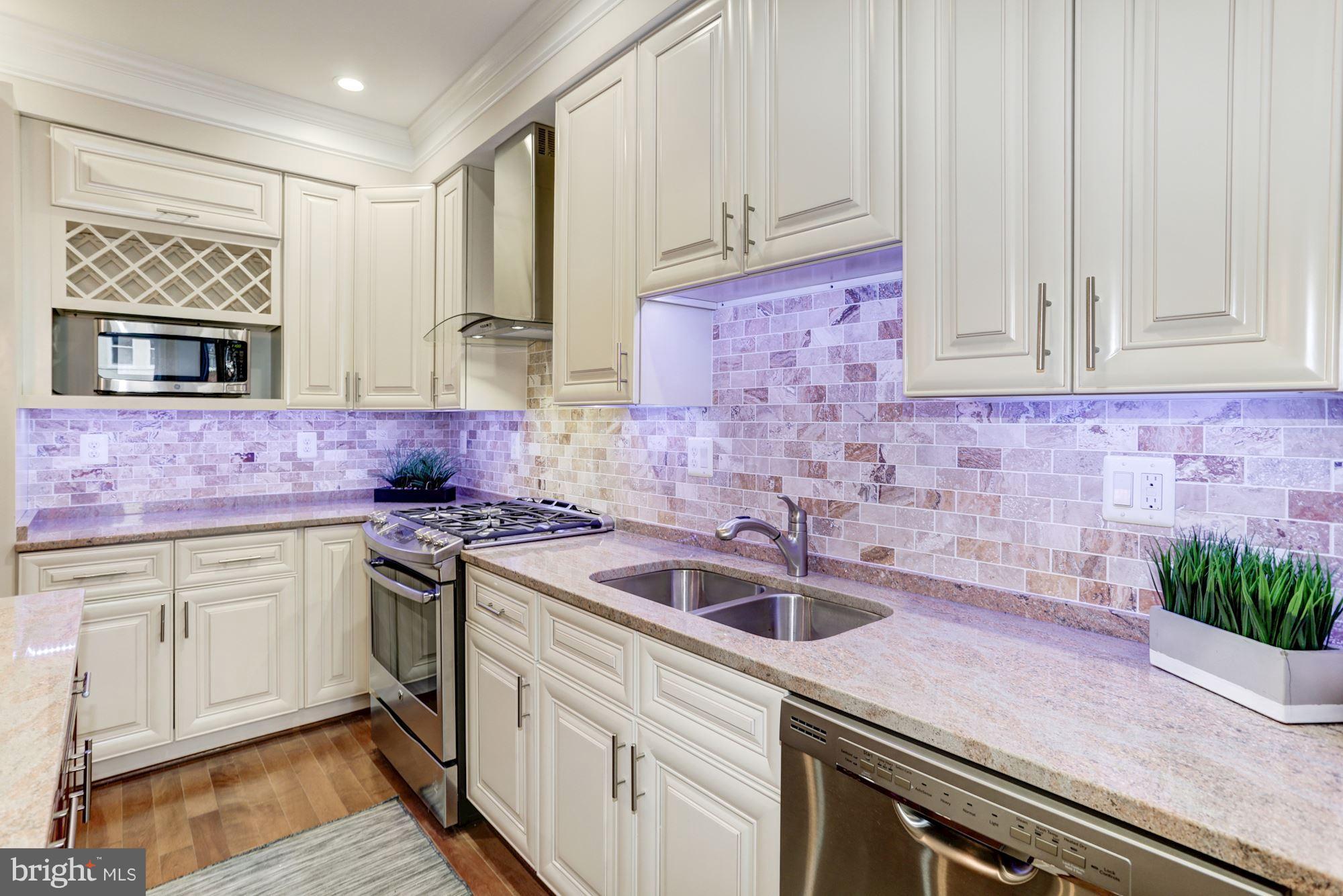 59 R Street Northeast, Unit 1 Washington, DC 20002 - Photo 17 of 40 a kitchen with stainless steel appliances granite countertop a sink stove and cabinets