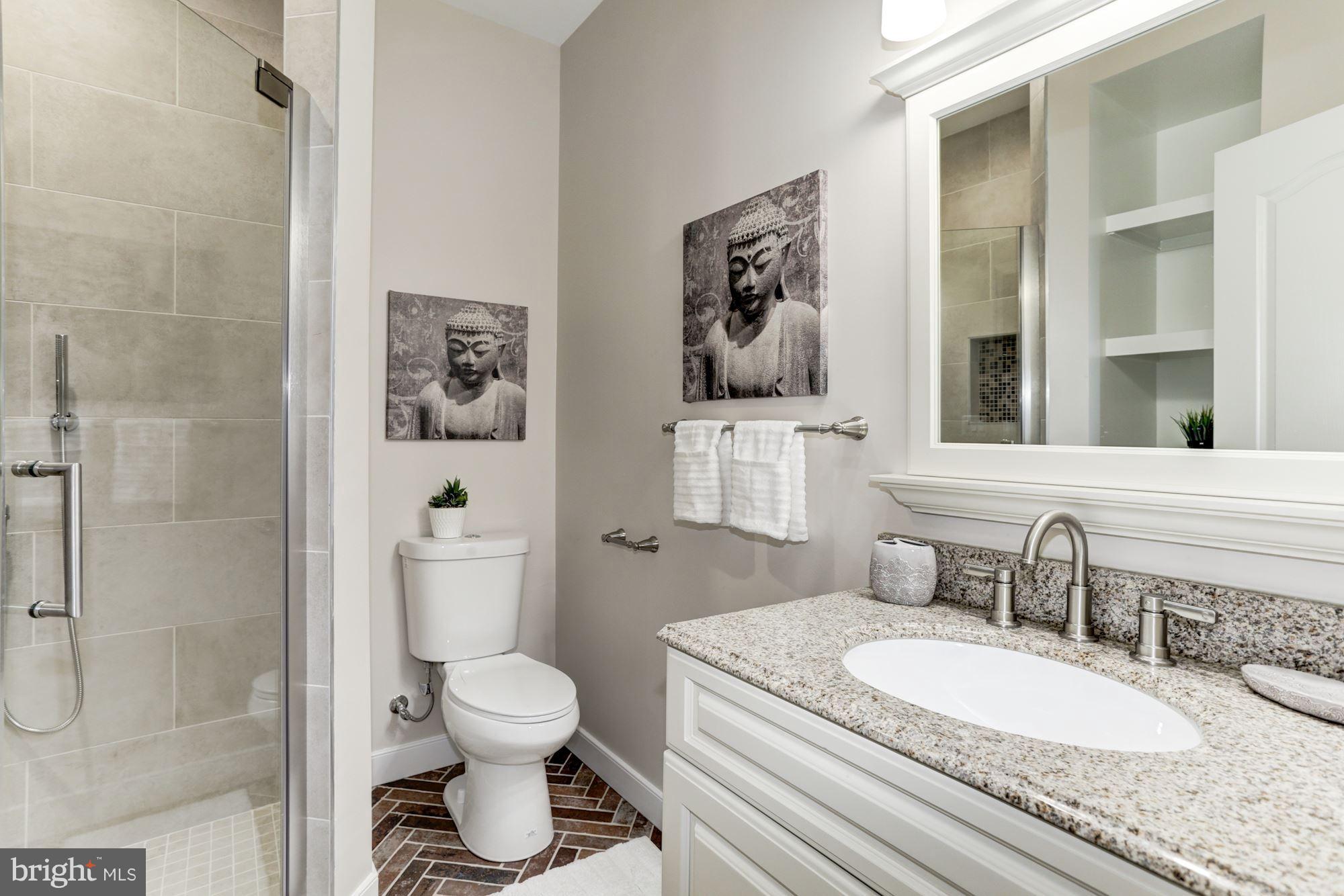 59 R Street Northeast, Unit 1 Washington, DC 20002 - Photo 22 of 40 a bathroom with a granite countertop toilet sink and mirror
