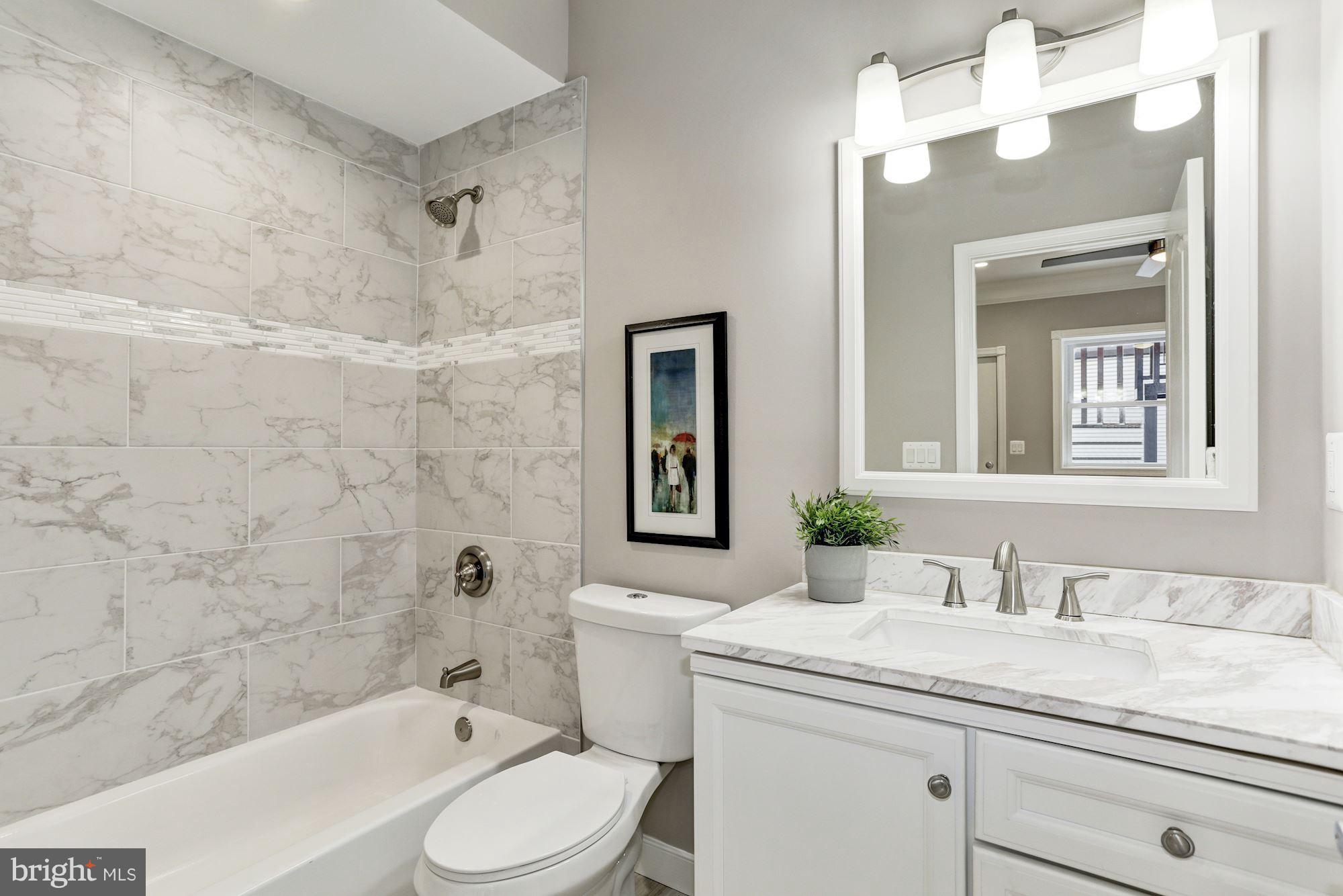 59 R Street Northeast, Unit 1 Washington, DC 20002 - Photo 38 of 40 a bathroom with a granite countertop sink mirror vanity and toilet