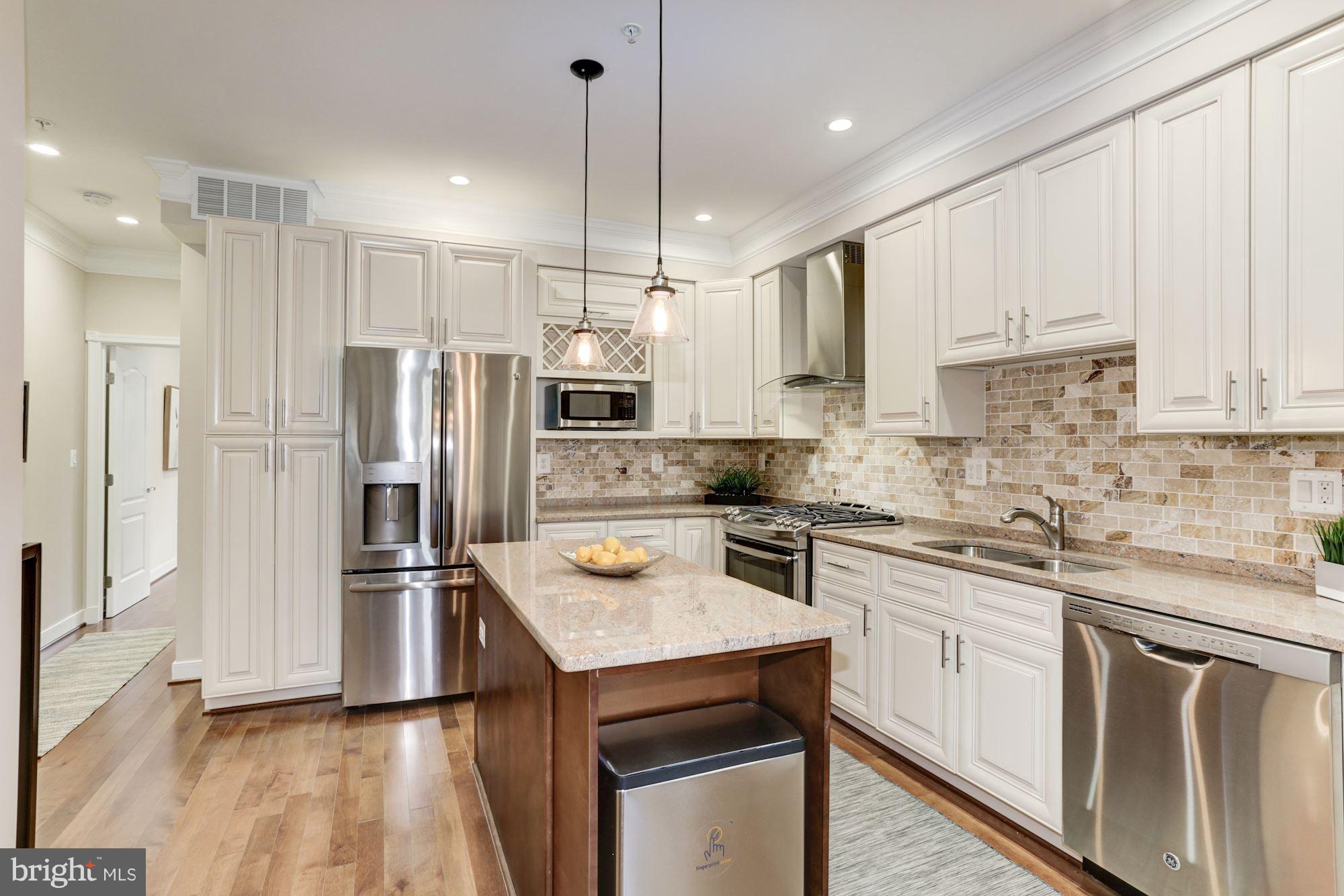 59 R Street Northeast, Unit 1 Washington, DC 20002 - Photo 10 of 40 a kitchen with white cabinets and stainless steel appliances