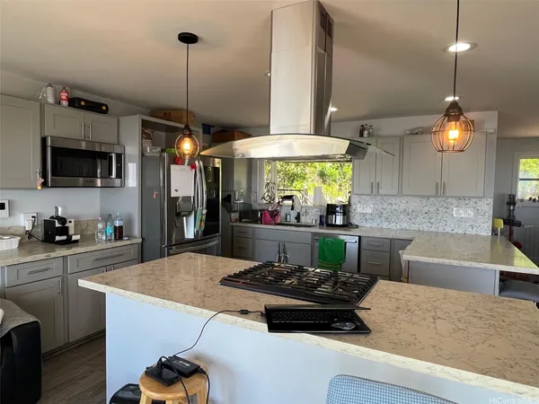 a kitchen with a stove a refrigerator and a wooden floor