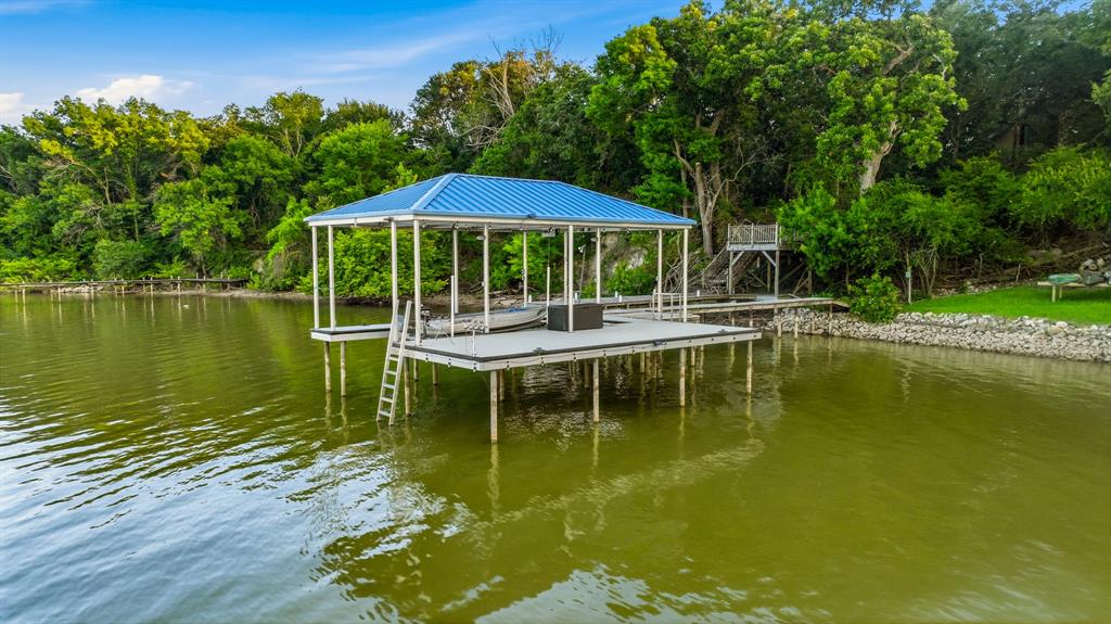 7250 Briar Road Azle, TX 76020 - Photo 33 of 40 Covered dock with a blue metal roof, featuring a boat lift and an attached ladder