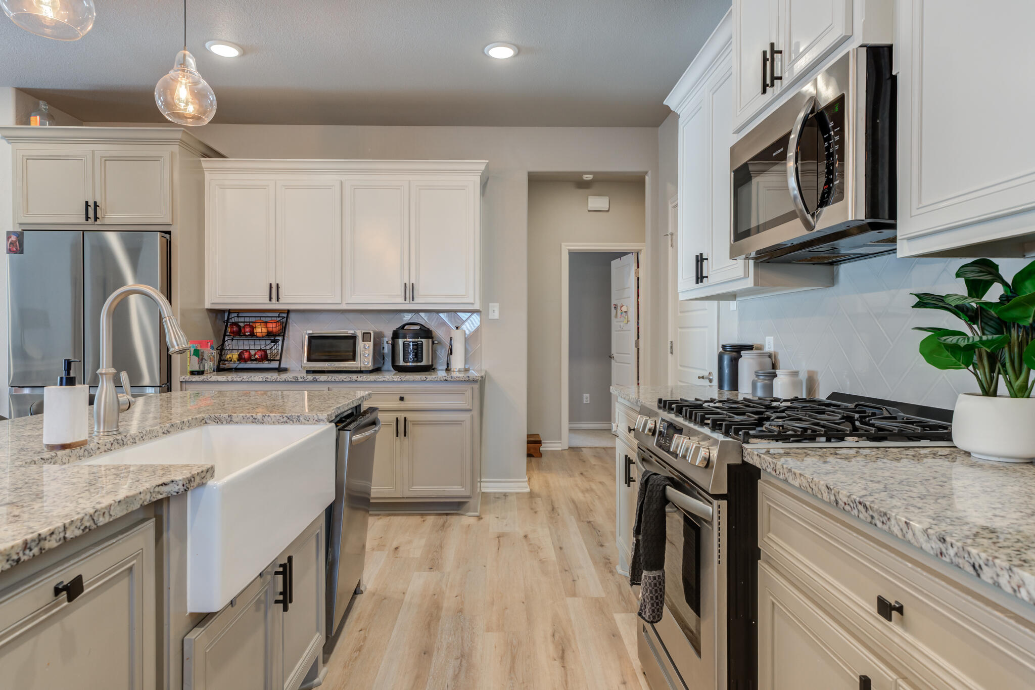 9609 Inverness Avenue Lubbock, TX 79424 - Photo 6 of 17 a kitchen with stainless steel appliances granite countertop a sink stove microwave and refrigerator