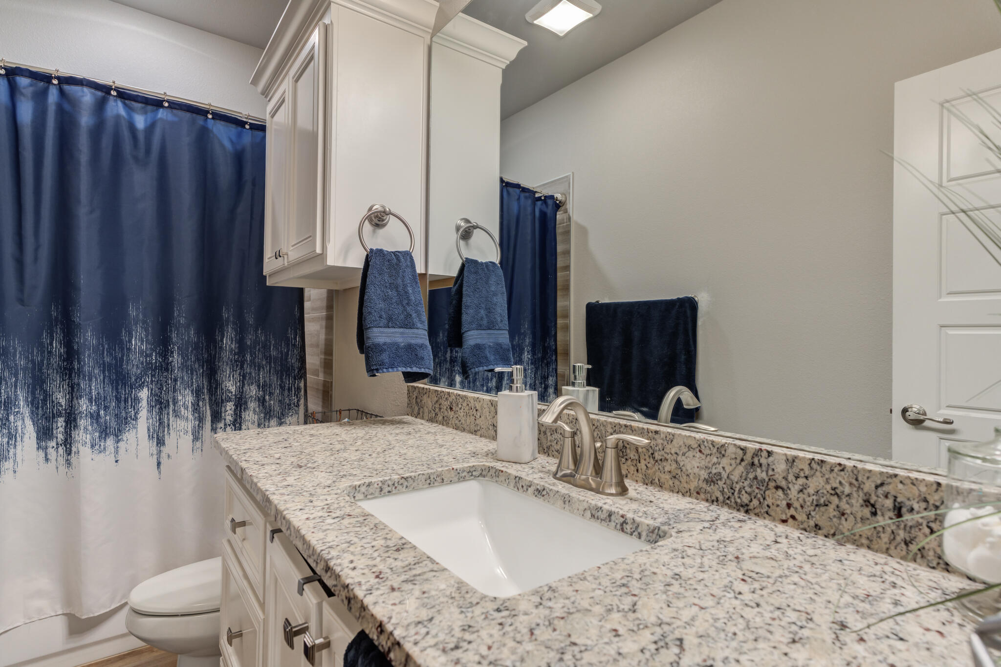 9609 Inverness Avenue Lubbock, TX 79424 - Photo 9 of 17 a bathroom with a granite countertop sink and a mirror