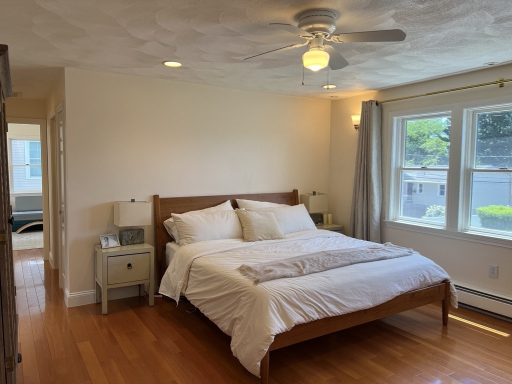 11 Garrison Road, Unit 1 Arlington, MA 02474 - Photo 29 of 42 a bedroom with a bed and a chandelier