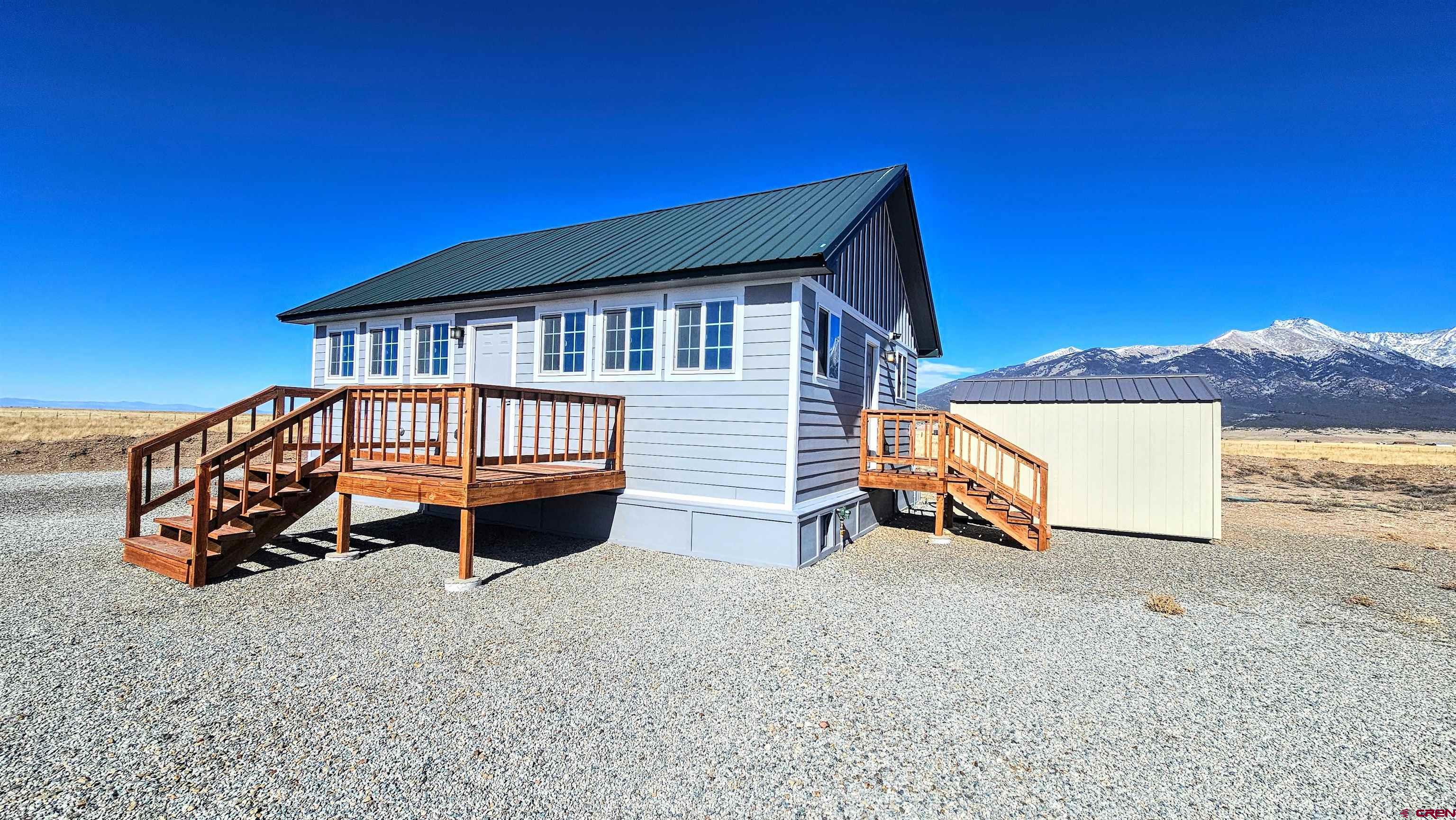 10547 Palm Road Blanca, CO 81123 - Photo 3 of 32 a backyard of a house with barbeque oven and outdoor seating