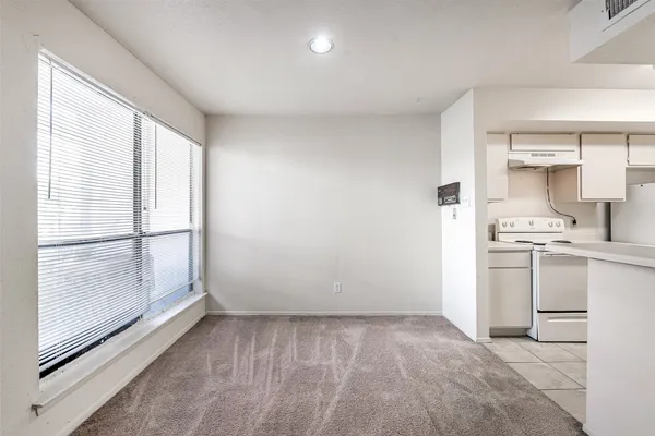 a view of a kitchen with white cabinets and wooden floor