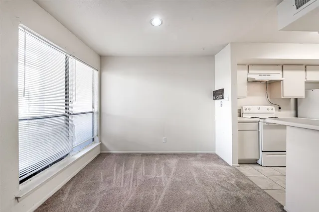 a view of a kitchen with white cabinets and wooden floor