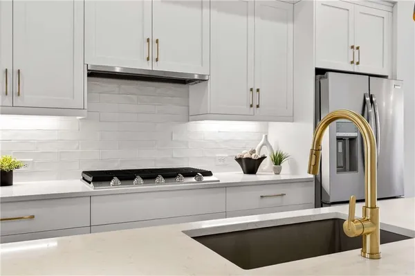 a kitchen with stainless steel appliances granite countertop a sink a stove a refrigerator and island with wooden floor