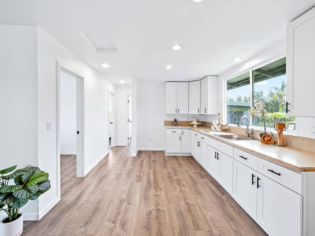 1907 Uhaloa Road Hilo, HI 96720 - Photo 10 of 23 a large kitchen with granite countertop a large counter top a sink stainless steel appliances and cabinets