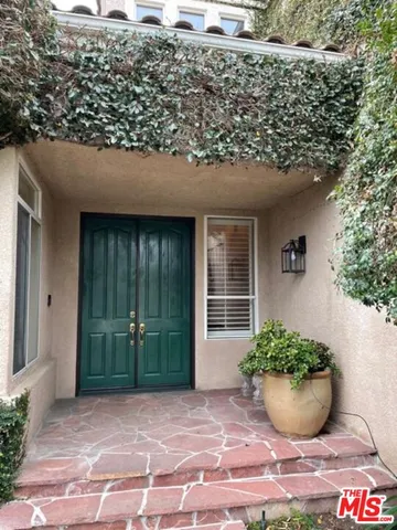 a view of a patio with table and chairs under an umbrella