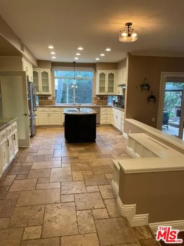 a large white kitchen with kitchen island granite countertop a large counter top and appliances