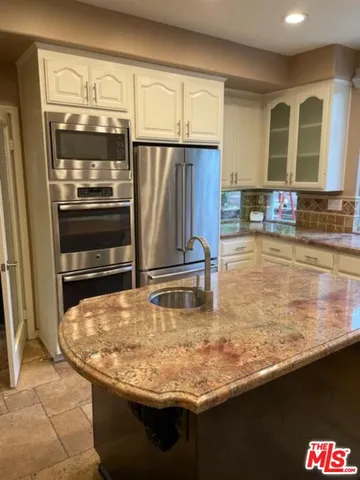 a kitchen with kitchen island a counter top and stove