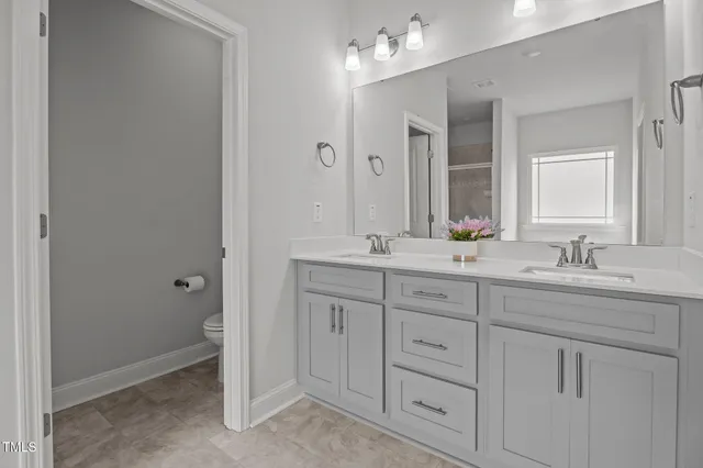 a bathroom with double sink and a mirror