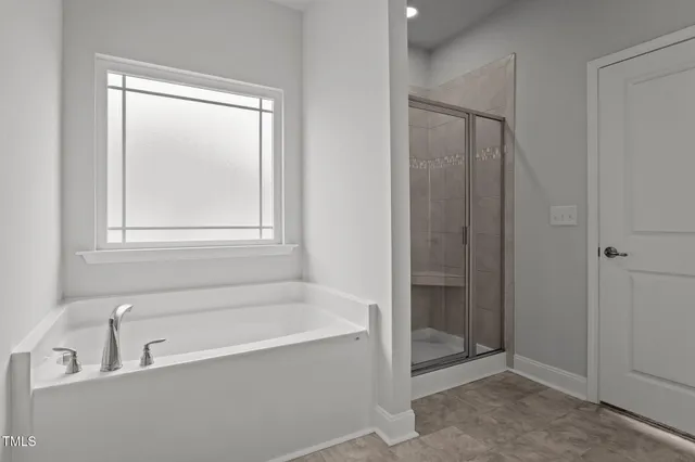a spacious bathroom with a bathtub and shower