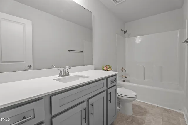a bathroom with a sink toilet vanity and shower