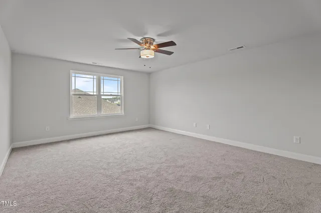 an empty room with windows and ceiling fan